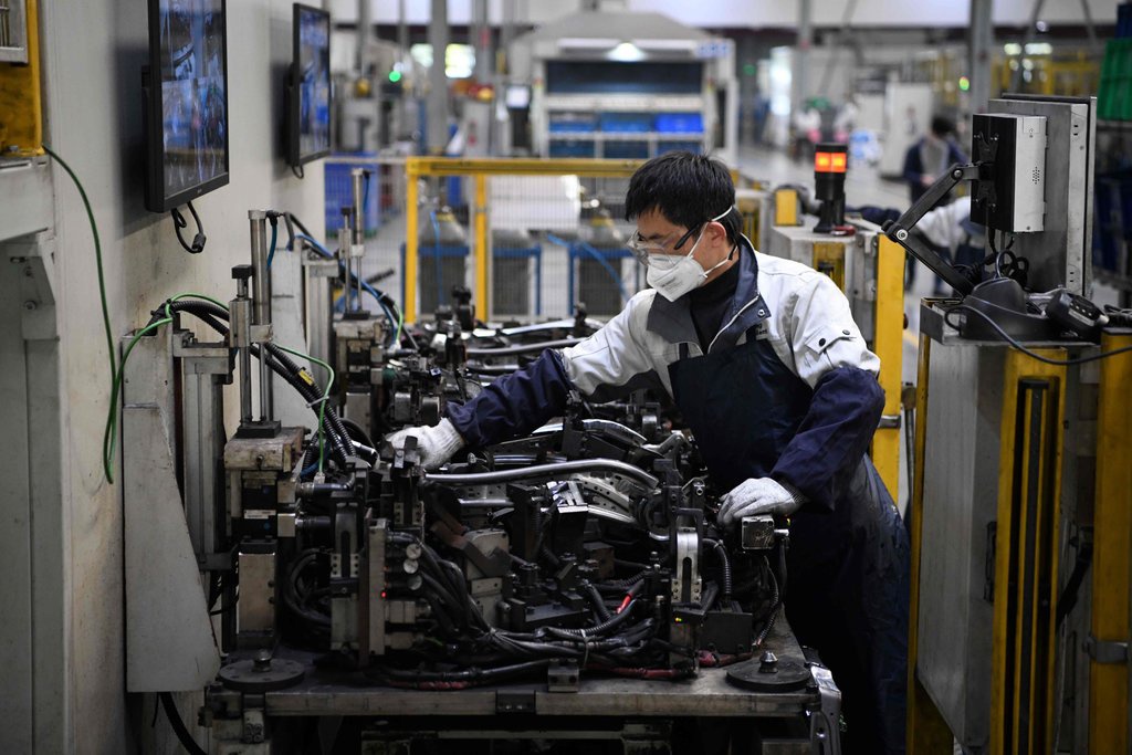Công nhân trở lại làm việc tại một nhà máy sản xuất bộ phận của xe hơi ở Thượng Hải. Ảnh: AFP.